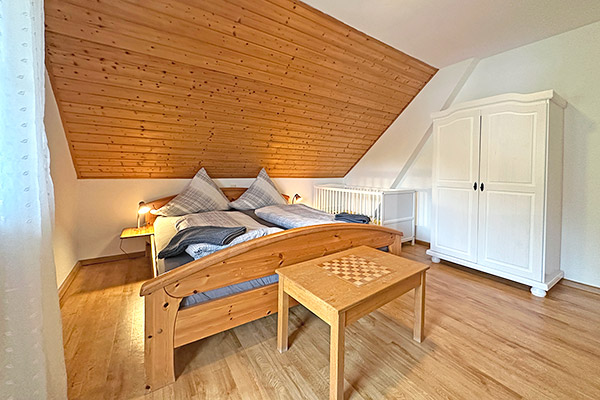 Schlafzimmer mit Doppelbett und Kinderbett